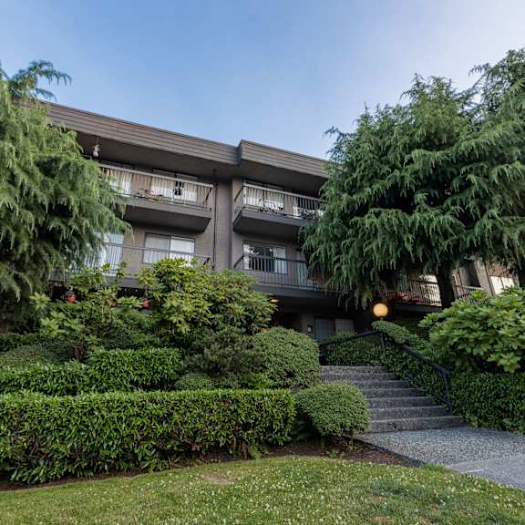 an apartment building with trees in front of it