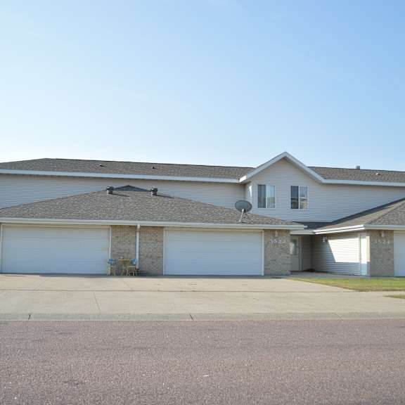 a house with a grey roof and a garage door.