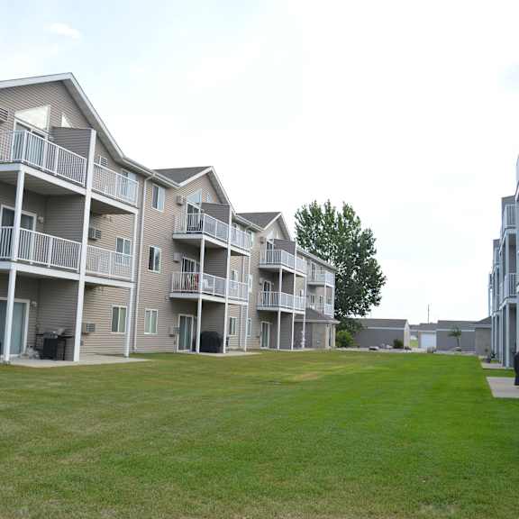 apartment complex with a green lawn in front.