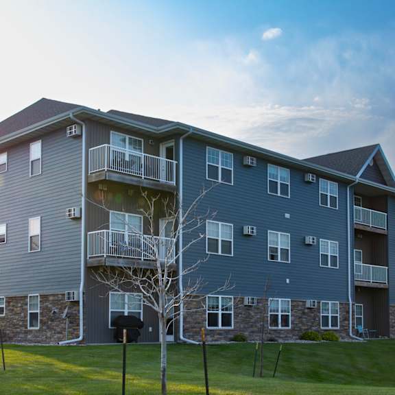 a large apartment building with a grassy area in front.