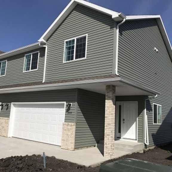 a grey house with a white garage door.