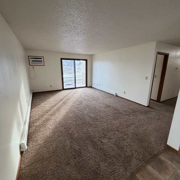 a room with a window and a brown wall.