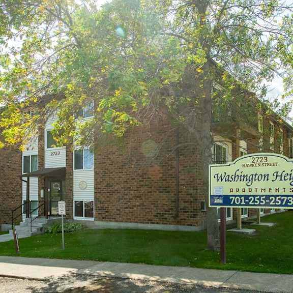 a sign for washington heights apartments is in front of a brick building.