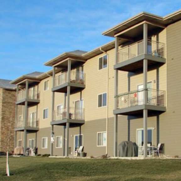 apartment complex with a red car parked in front.
