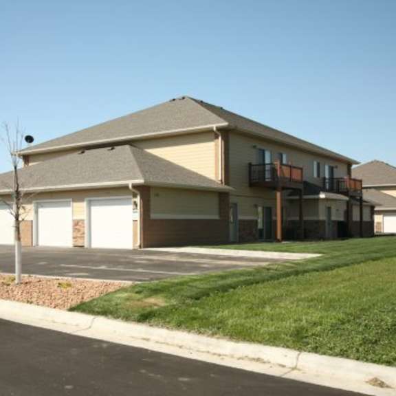 a building with a brown roof and white garage doors.