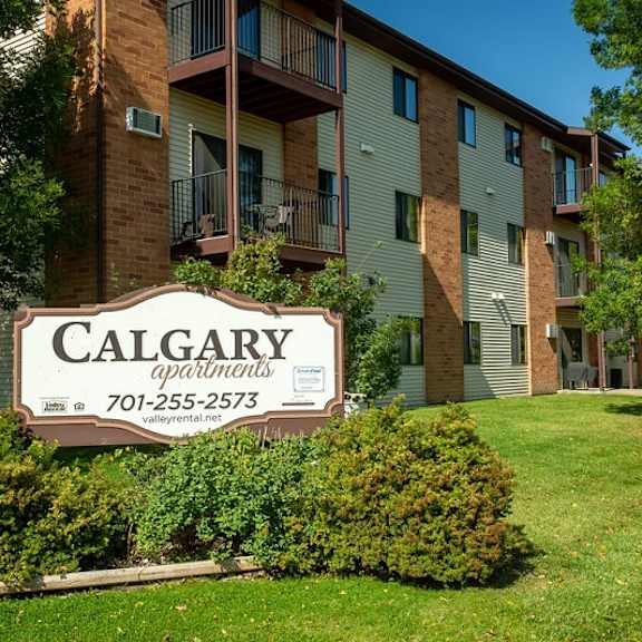 a calgary apartments sign in front of a building.