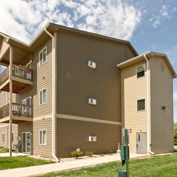 a large apartment building with multiple balconies and doors.