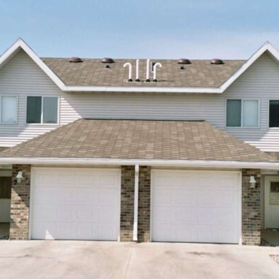 a two-story house with a garage on the first floor.