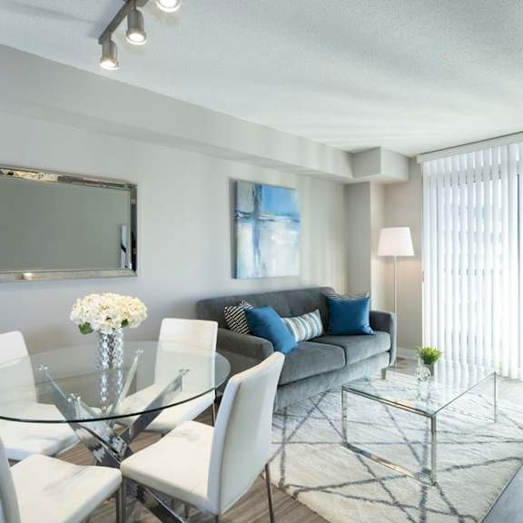a living room with a glass table and chairs