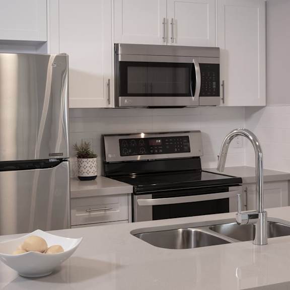 a kitchen with a sink a stove and a refrigerator