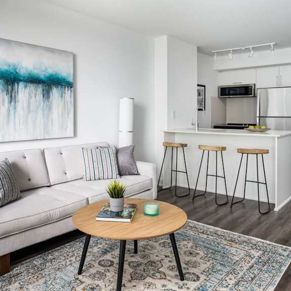 a living room with a couch a table and a kitchen in the background