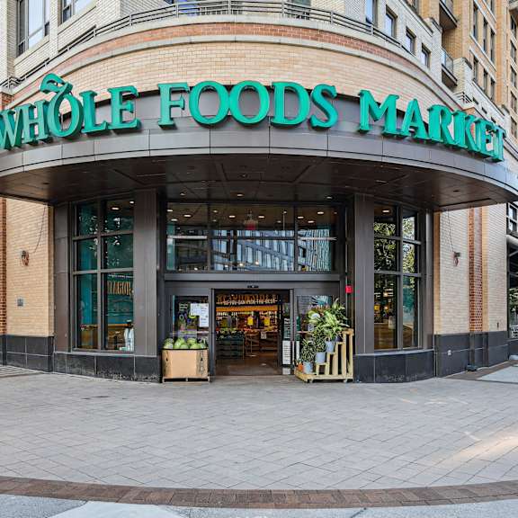 A Whole Foods Market storefront with a green awning and a sign above the entrance.