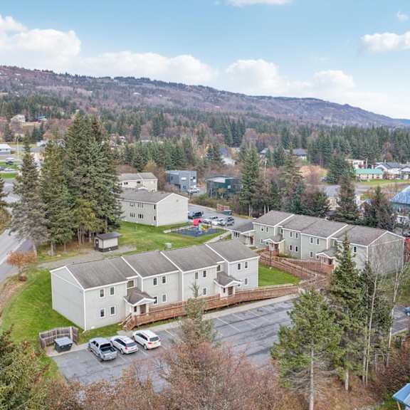 a large white building surrounded by trees and a parking lot.