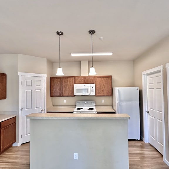 a kitchen with white cabinets and a white fridge.