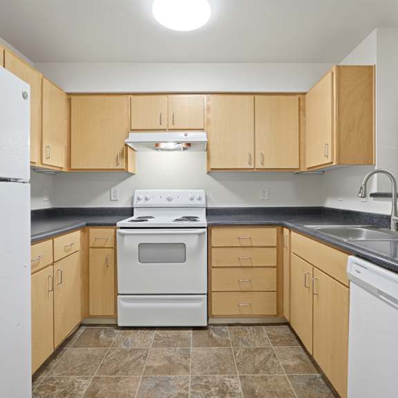 A kitchen with a white refrigerator and a white stove top oven.