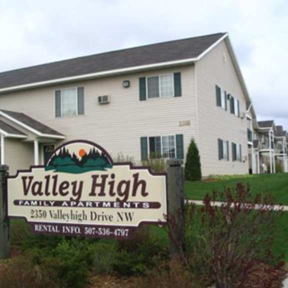 a sign for valley high family apartments is in front of a building.