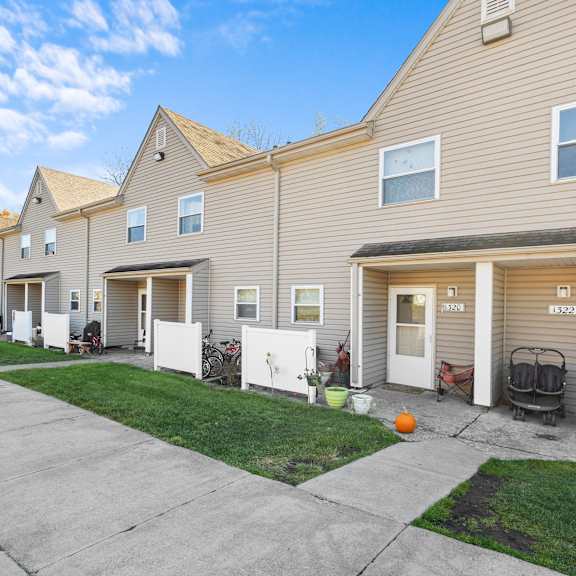 a row of houses with garages and front yards.
