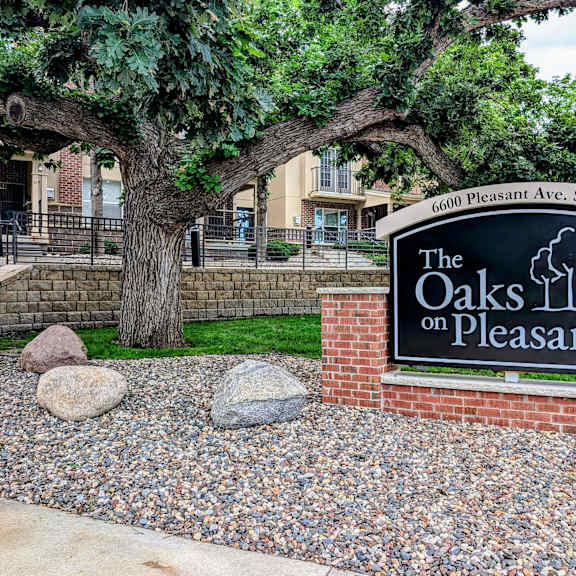 the oaks on pleasant sign in front of trees and rocks