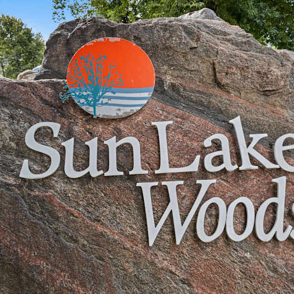 a rock with the sun lake woods logo on it