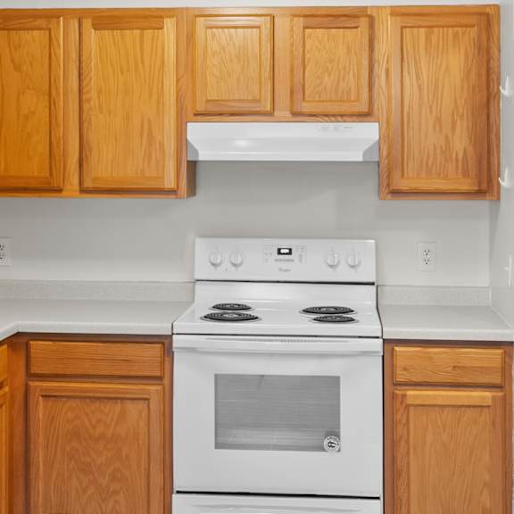 a white refrigerator is in a kitchen with wooden cabinets.