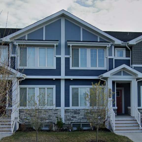 a blue two-story house with a front porch.