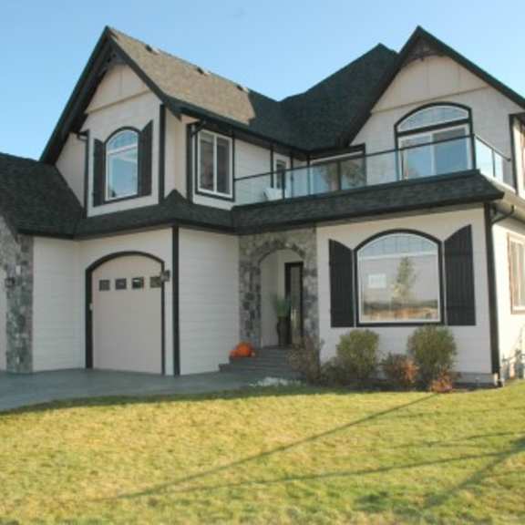 a large two-story house with a balcony on the second floor.