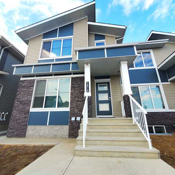 a modern house with a front porch and stairs leading to the entrance.