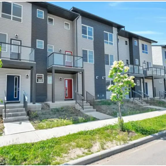 a row of town houses with stairs and a sidewalk