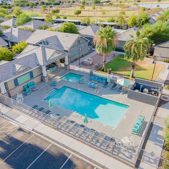 an aerial view of a swimming pool and a house with a pool and chairs at villas on olive, peoria, arizona