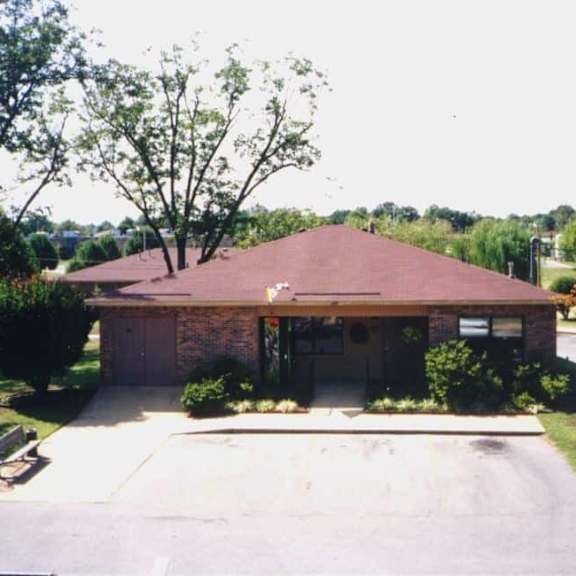 a house with a brown roof and a driveway in front.