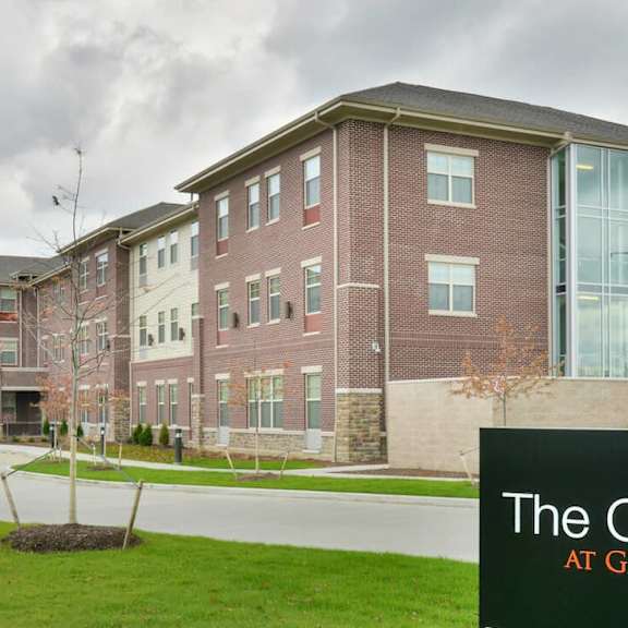 the commons at garden lake is a large, multi-story building with a grassy front yard.