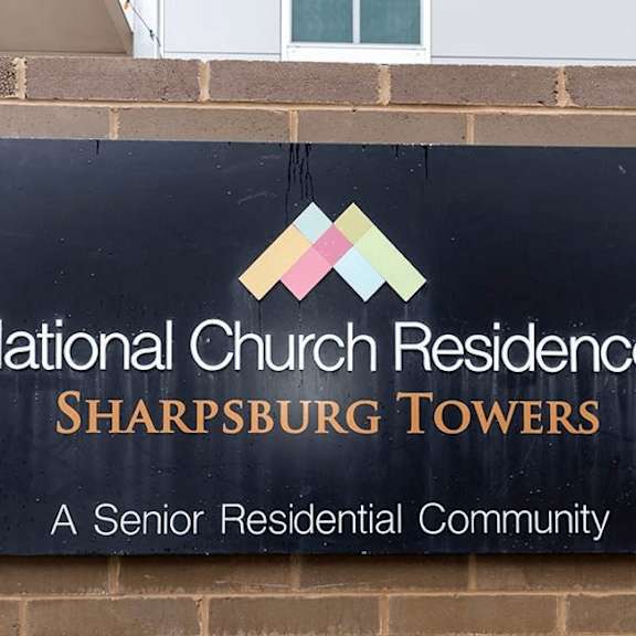 a sign for national church residences sharpsburg towers, a senior residential community.