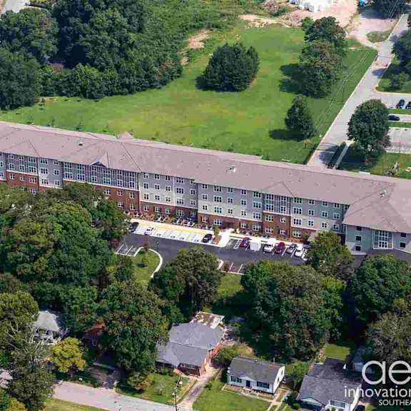 an aerial view of a building with a parking lot in front of it.