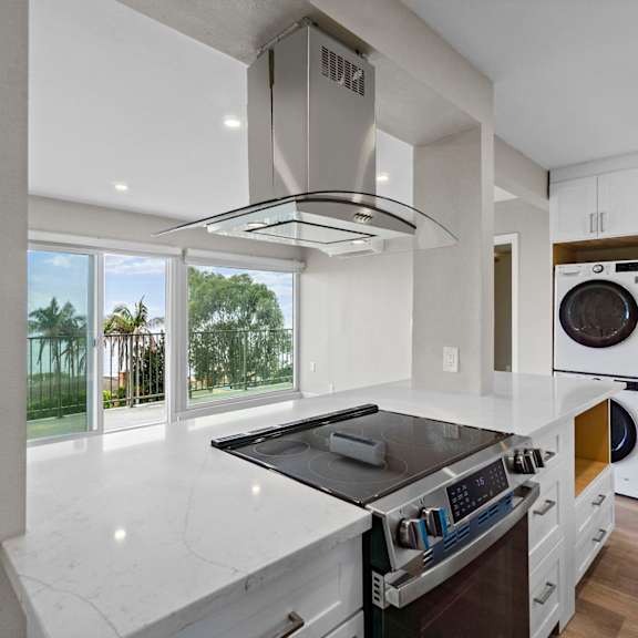 a modern kitchen with a stove top oven and a washing machine built into the cabinetry.at ocean edge @ laguna beach, laguna beach, 92651