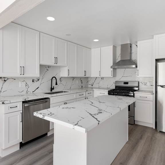 a kitchen with white cabinets and white marble countertops at seaview terrace apartment homes, san clemente, 92672