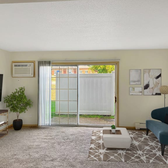 a living room with a sliding glass door leading to a backyard