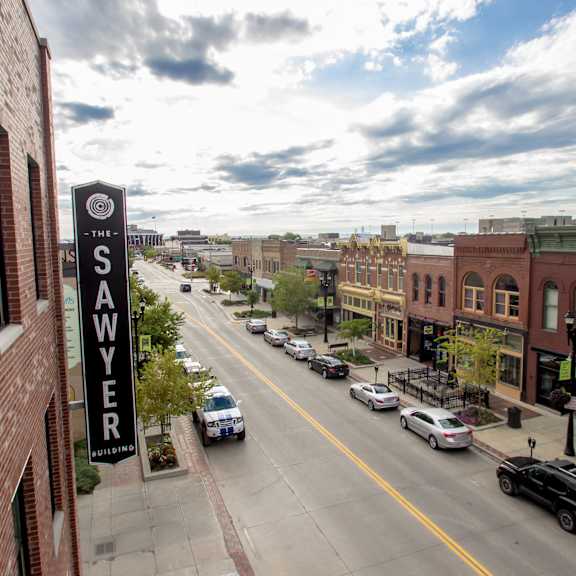 a street view of a city with cars parked on the side of the road.