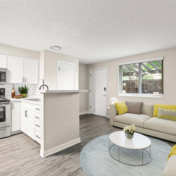 spacious living room with sectional sofa, large window, air conditioning unit, and full kitchen in view at 1443 elizabeth in denver, co