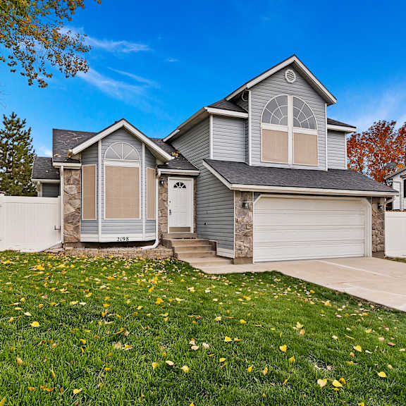 a house with a grey roof and a white garage door.