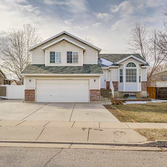 a house with a white garage door is in the foreground.