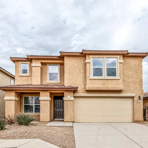 a two-story house with a garage and a driveway.