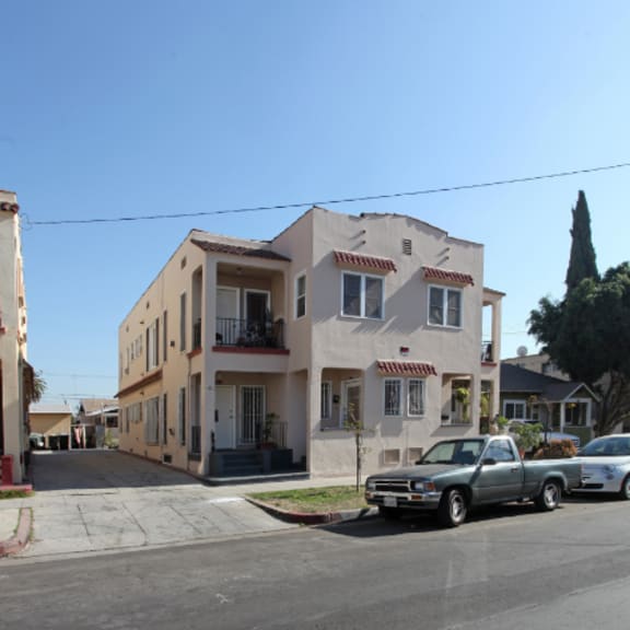 an apartment building on a street with cars parked in front of it