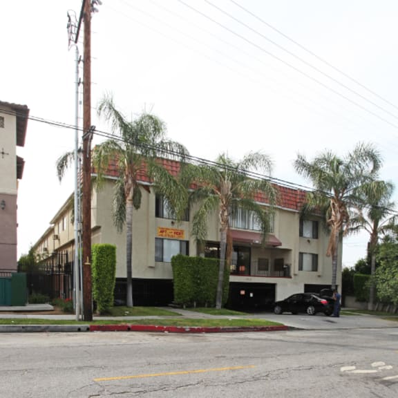 a building with palm trees in front of it on a street