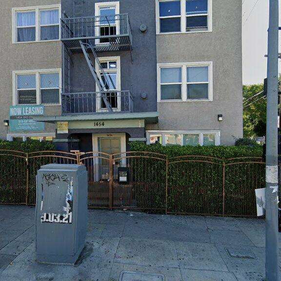 an apartment building with a parking meter in front of it