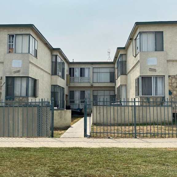 a row of houses with a sidewalk and a fence