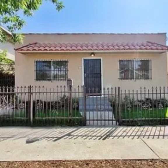 a house with a fence and a gate in front of it