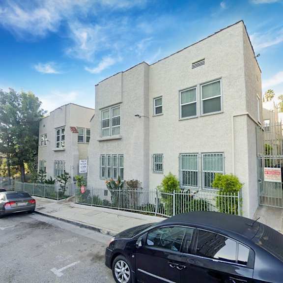an apartment building with cars parked in front of it