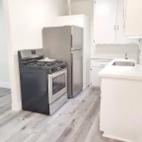 an empty kitchen with a stove and a refrigerator