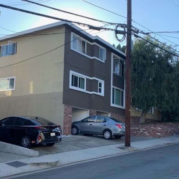 an apartment building with cars parked in front of it