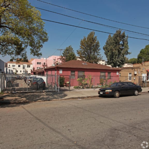 a pink house with a car parked on a street